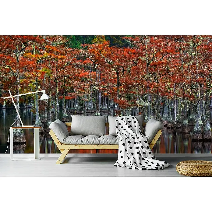 Papermoon Premium collection Fototapete Ruhige Bucht - B x H: 350 x 260 cm, Vlies - Gemütliches Wohnzimmer mit einem stilvollen Sofa, einem Beistelltisch mit Lampe und einem dekorativen Hocker vor einer Waldtapete.