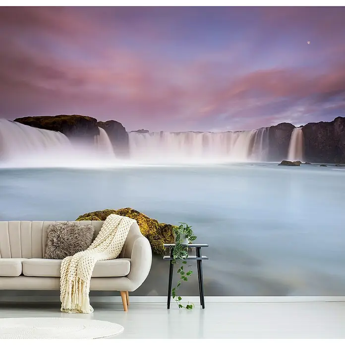 Papermoon Premium collection Fototapete Godafoss und Mond - B x H: 500 x 280 cm, Vlies - Gemütliches Wohnzimmer mit stilvollem Sofa vor einer atemberaubenden Wasserfall-Fototapete, die eine beruhigende Atmosphäre schafft.