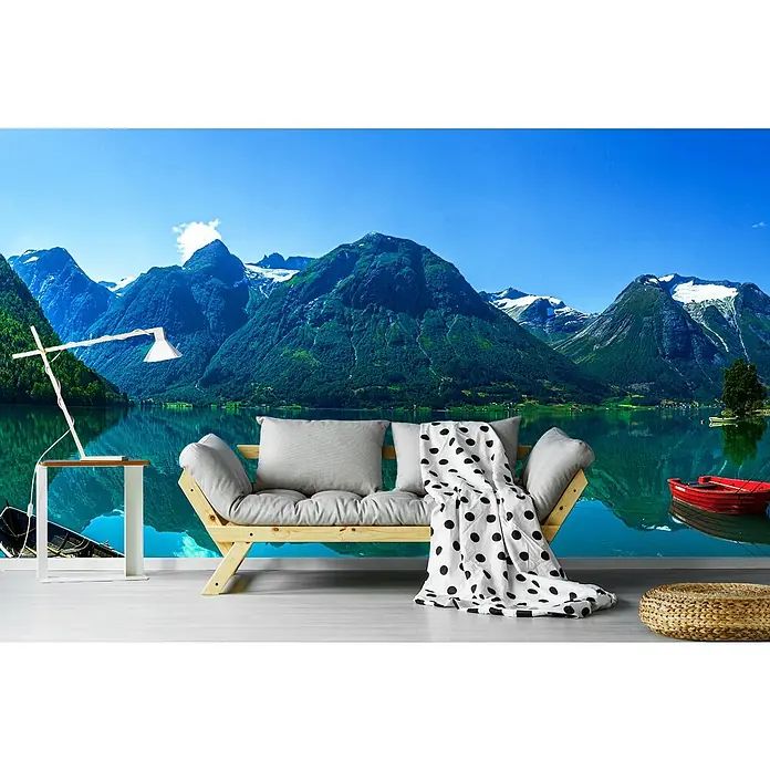 Papermoon Premium collection Fototapete Der Gletschersee - B x H: 250 x 186 cm, Vlies - Einladender Raum mit einem modernen Sofa, Kissen und einer Decke mit Punkten vor einer malerischen Bergkulisse.