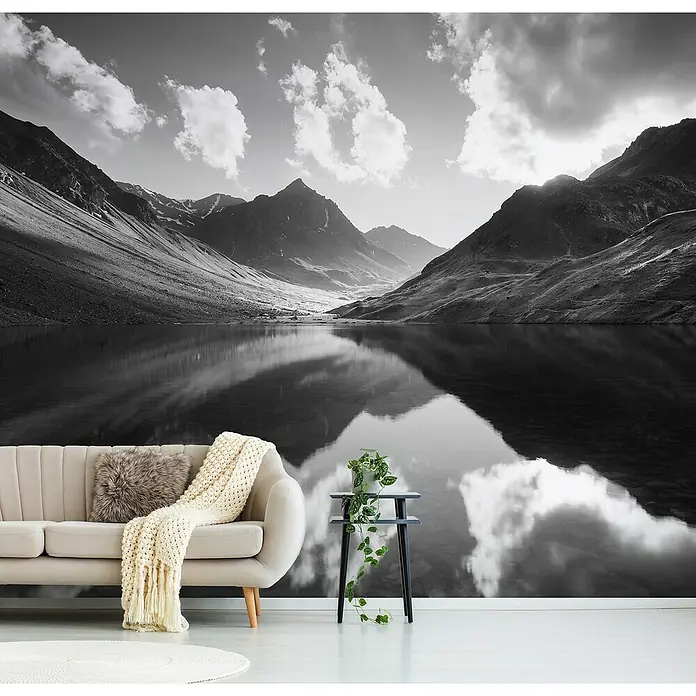 Papermoon Premium collection Fototapete Bergreflexion - B x H: 400 x 260 cm, Vlies - Wohnraum mit stilvollem Sofa, rundem Teppich und Blick auf eine ruhige Bergkulisse als Wandbild.