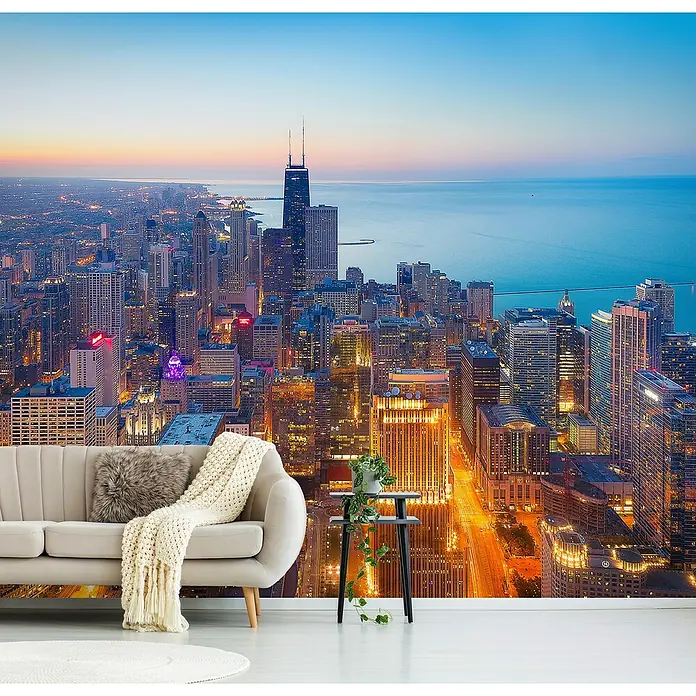 Papermoon Premium collection Fototapete Die herrliche Meile - B x H: 250 x 186 cm, Vlies - Detailaufnahme eines Wandbildes mit einer Skyline bei Nacht, mit Couch, Kissen, Decke, Tisch und Topfpflanze dekoriert.