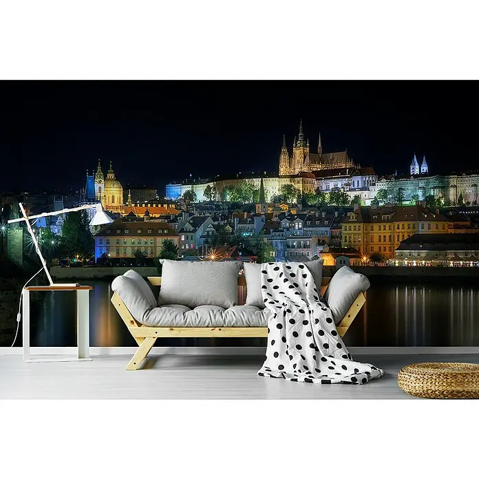 Papermoon Premium collection Fototapete Prag Nachts - B x H: 200 x 149 cm, Vlies - Wandbild mit Nachtansicht von Prag. Das Fototapeten-Design zeigt ein Sofa mit Kissen und eine Lampe vor der Skyline von Prag bei Nacht.