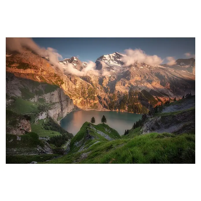 Papermoon Premium collection Fototapete Oeschinsee - B x H: 250 x 186 cm, Vlies - Malerische Aussicht auf einen Bergsee mit schneebedeckten Gipfeln, grünen Hängen und zwei Bäumen auf einem Hügel für eine ruhige Naturlandschaft.