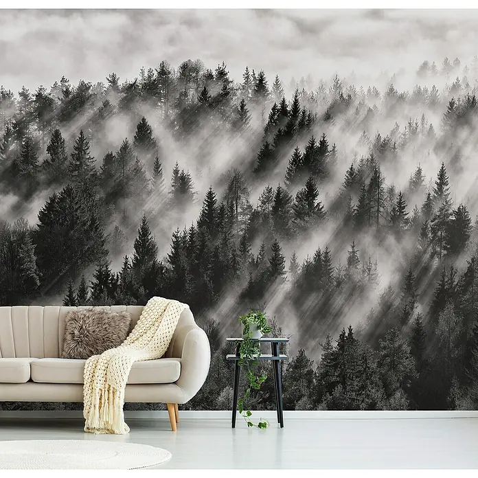 Papermoon Premium collection Fototapete Baumspitzen - B x H: 300 x 223 cm, Vlies - Ein Wohnzimmer mit einem beigen Sofa, einem Beistelltisch und einer Waldtapete in Schwarzweiß, die eine friedliche und beruhigende Atmosphäre schafft.
