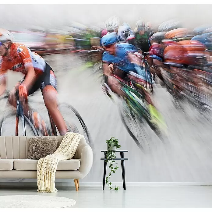 Papermoon Premium collection Fototapete Ausbrechen - B x H: 200 x 149 cm, Vlies - Großformatige Wandtapete mit verschwommenem, dynamischem Bild von Radrennfahrern, die ein modernes Wohnzimmer mit beigem Sofa und Pflanzentisch schmückt.