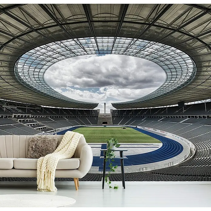Papermoon Premium collection Fototapete Berlin - B x H: 200 x 149 cm, Vlies - Das Foto zeigt ein stilvolles Wohnzimmer mit einer auffälligen Tapete des Berliner Olympiastadions. Das Sofa und die Dekorationen ergänzen das Stadionmotiv.