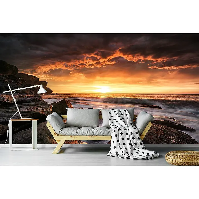 Papermoon Premium collection Fototapete Kapslöcher - B x H: 500 x 280 cm, Vlies - Stilvolles Interieur mit einem Holzbettsofa, hellgrauen Kissen, einer schwarz-weiß gepunkteten Decke und einer modernen Lampe vor einer Strandtapete.