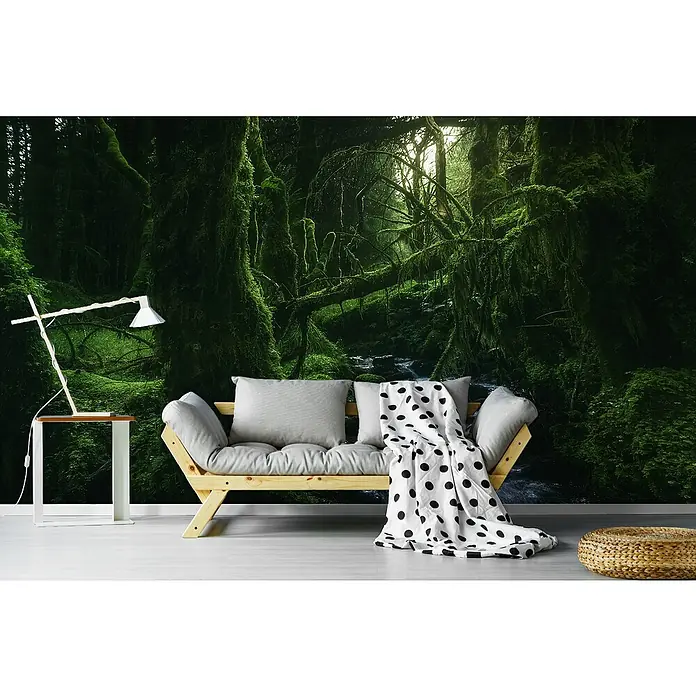 Papermoon Premium collection Fototapete Mystischer Märchenwald - B x H: 250 x 186 cm, Vlies - Wohnzimmer mit einem hellen Holzsofa, grauen Kissen und einer gepunkteten Decke vor einer grünen Waldtapete.