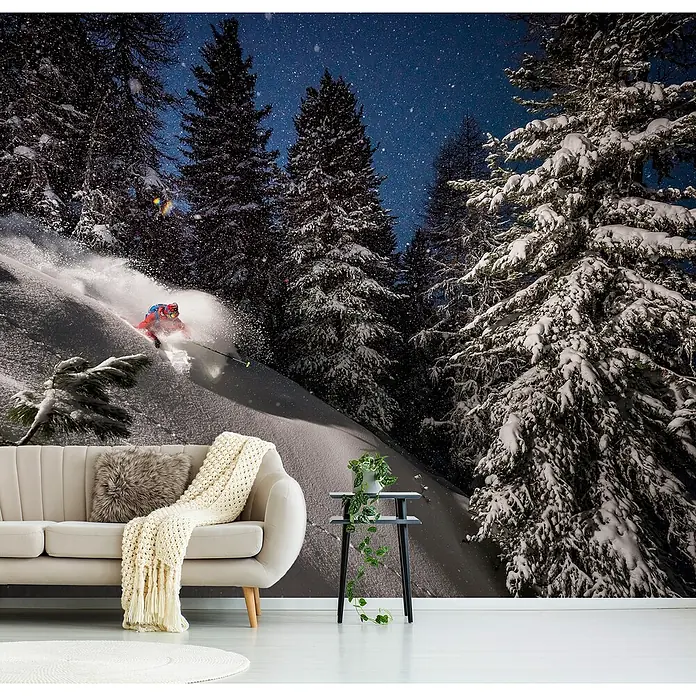 Papermoon Premium collection Fototapete Skipiste - B x H: 450 x 280 cm, Vlies - Eine stilvolle Inneneinrichtung mit einer beeindruckenden Fototapete, die eine winterliche Waldszene mit Skifahrer zeigt, umgeben von schneebedeckten Bäumen.