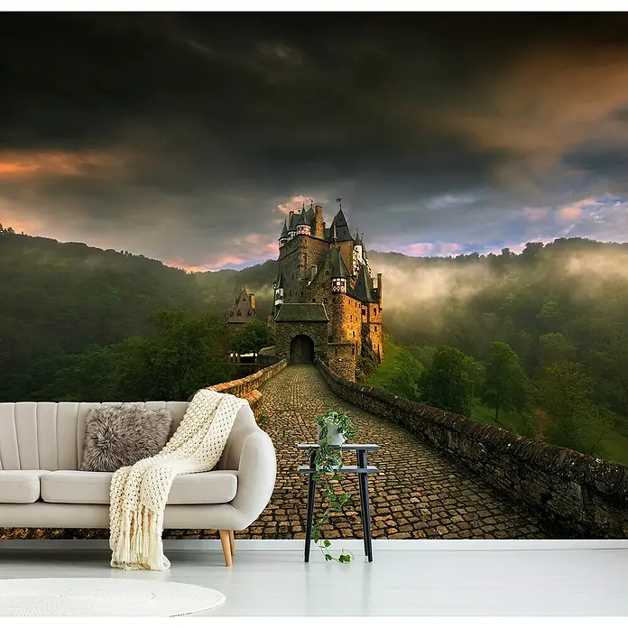 Papermoon Premium collection Fototapete Eltz II - B x H: 200 x 149 cm, Vlies - Eine elegante Wohnzimmerkulisse mit einer Wandtapete, die ein malerisches Schloss zeigt, ergänzt durch ein stilvolles Sofa und einen Beistelltisch.