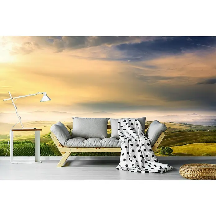 Papermoon Premium collection Fototapete Poe Belvee's Sunrise - B x H: 450 x 280 cm, Vlies - Moderne Wohnzimmerszene mit einem stilvollen Sofa, einer Lampe und einer dekorativen Decke vor einer malerischen Landschaftstapet.