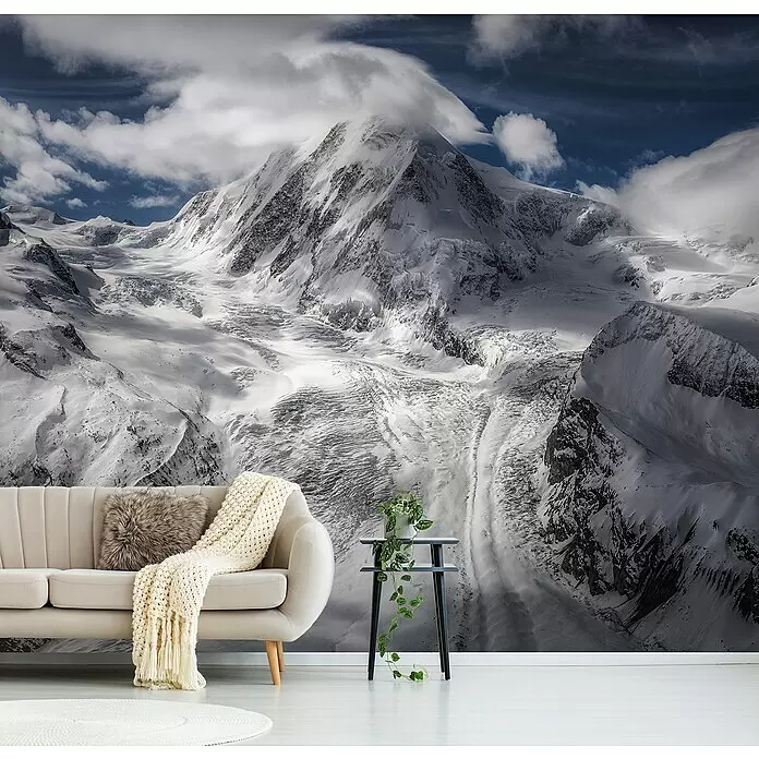 Papermoon Premium collection Fototapete Gletscher - B x H: 200 x 149 cm, Vlies - Großes Tapetenbild einer majestätischen, schneebedeckten Bergkette mit Wolken, hinter einem hellen Sofa angebracht.