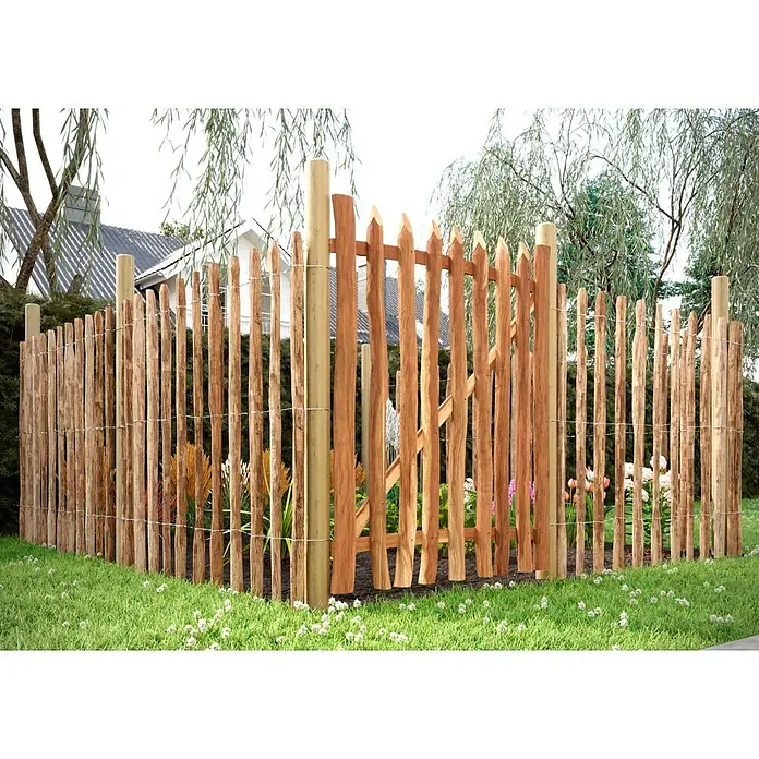 T & J Staketen Rollzaun Rollo 8-10 cmB x H: 1.000 x 120 cm, Holz - Ein naturnaher, rustikaler Holzzaun mit spitz zulaufenden Latten umrandet einen Garten mit üppiger Vegetation. Der Zaun bietet Schutz und Privatsphäre.