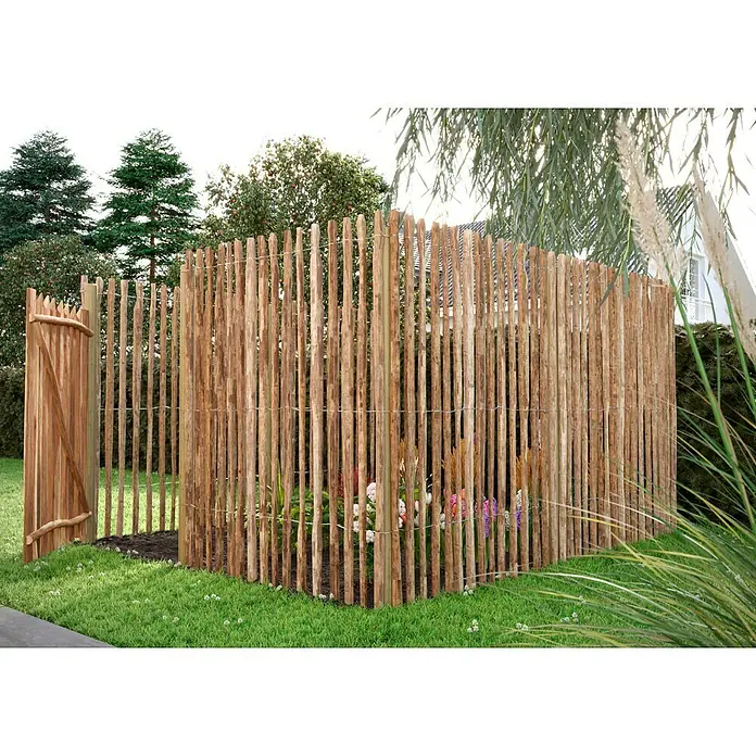 T & J Pfosten - 8 x 8 x 175 cm, Passend für: Jäger- und Staketenzaun, Braun - Ein rustikaler, hölzerner Staketenzaun umgibt einen kleinen Garten mit Blumen, der eine natürliche und charmante Atmosphäre erzeugt.