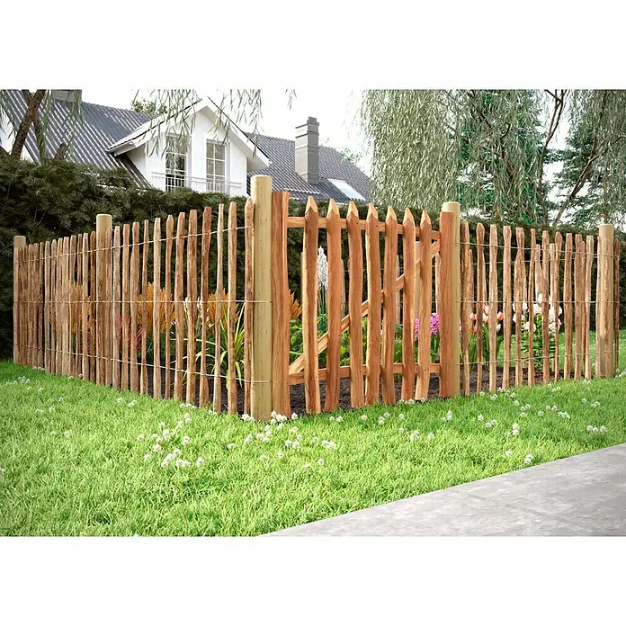 T & J Pfosten - 8 x 8 x 125 cm, Passend für: Jäger- und Staketenzaun, Braun - Ein rustikaler Holzzaun mit spitz zulaufenden Pfählen und einem passenden Gartentor umgibt einen blühenden Garten in einem Wohngebiet.