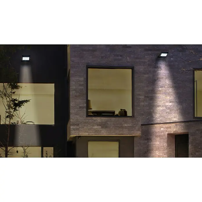 Ledvance LED-Solar-Außenwandleuchte Endura FloodSolarzelle, Kaltweiß, Schwarz - Außenansicht eines modernen Hauses mit zwei LED-Strahlern, die die Fassade beleuchten und architektonische Details hervorheben.