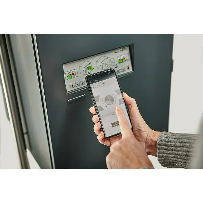 Burg-Wächter Paketbox eBoxx GV 645 - L x B x H: 45 x 57,5 x 76 cm, Anthrazit, Stahl, Namensschild, Fassungsvermögen: 197 l - Ein Händepaar bedient ein Smartphone mit der KeyApp von BURG-WÄCHTER vor einem grauen Schließfachsystem.