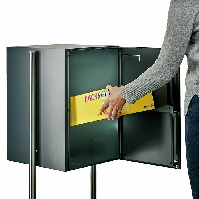 Burg-Wächter Paketbox eBoxx GV 645 - L x B x H: 45 x 57,5 x 76 cm, Anthrazit, Stahl, Namensschild, Fassungsvermögen: 197 l - Ein grauer Briefkasten mit einer gelben PACKSET-Sendung wird von einer Person befüllt, ideal für sichere Paketlieferungen.