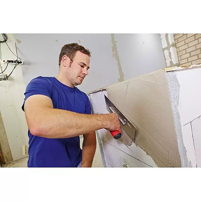 Quick-Mix Hagalith Kalkzement-Haftputz FF - 40 kg - Mann trägt hellbeigen Putz mit einer Glättkelle auf eine Wand auf.