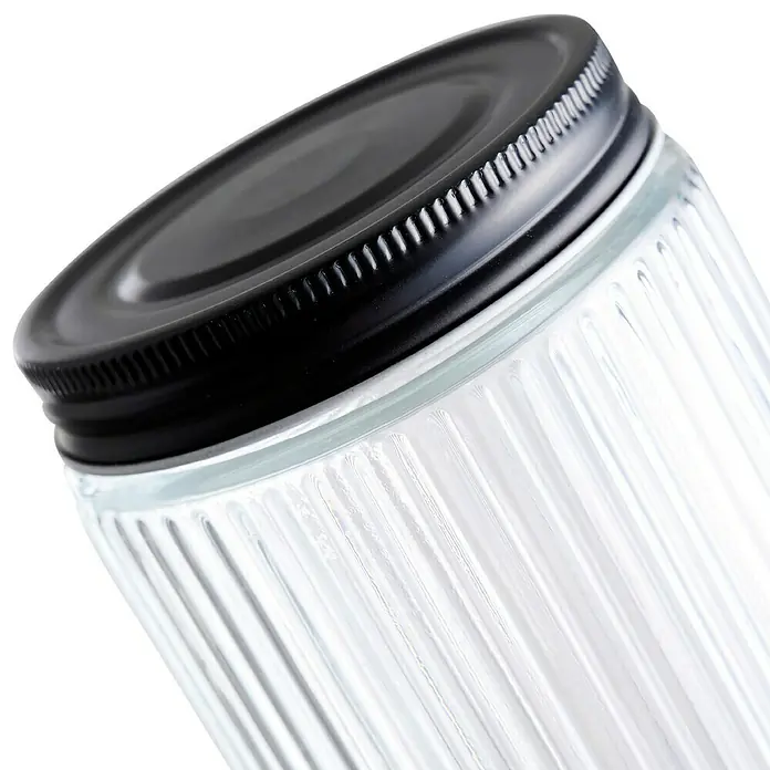 Frasco con relieve - Ø x Al: 9,2 x 19,5 mm, 900 ml, Vidrio - Primer plano de un recipiente de vidrio con textura acanalada y tapa negra. Perfecto para cocina o almacenamiento en despensa.