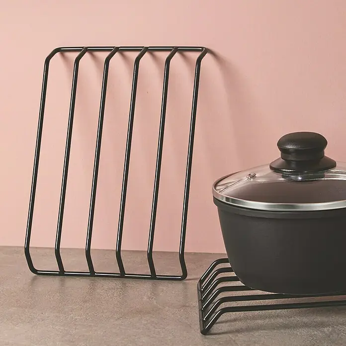 Salvamantel - 17 x 24 x 2,5 cm, Metal - Un primer plano de un soporte para tapas de ollas y una olla sobre una mesa, ideal para organizar tu cocina.