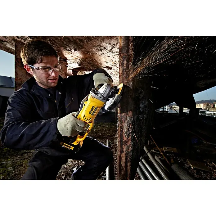 DeWalt XR 18V Akku-Winkelschleifer DCG412M2 - 2 Akkus, 4 Ah, Durchmesser Scheibe: 125 mm - Mann schleift Metall mit einem DeWALT Winkelschleifer, Funken fliegen. Ideal für Handwerker und DIY-Projekte mit hoher Leistung.