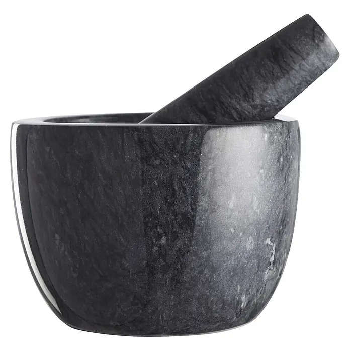 Mortero de cocina - Ø x Al: 12 x 9 cm, Piedra - Primer plano de un mortero de piedra con mano, ideal para moler hierbas y especias en la cocina.