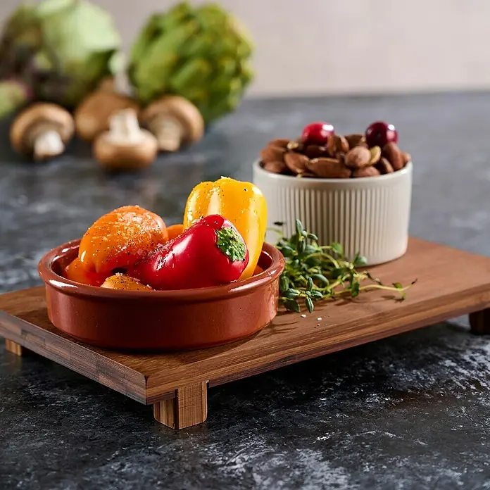 Bandeja Tabla - 15 x 26 x 3 cm, Madera - Deliciosos pimientos rellenos en un cuenco rústico de terracota, servidos con almendras y arándanos rojos en una bandeja de madera.
