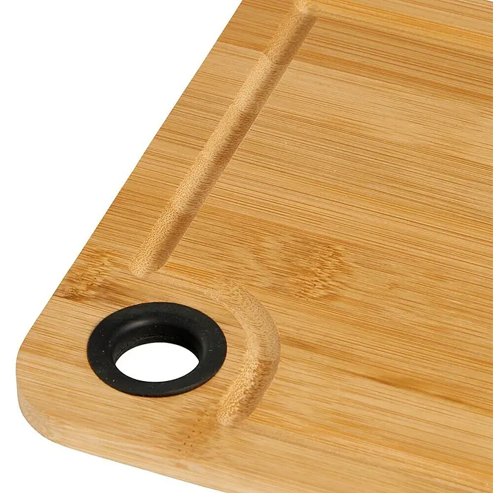 Tabla de cortar - 20 x 28 x 1 cm, Bambú - Primer plano de una tabla de cortar de bambú con ranura para jugos y agujero, ideal para cortar y servir alimentos.