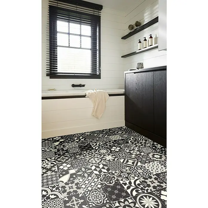 Beauflor PVC-Boden Meterware Tex-Style - Sonstige, Breite: 300 cm, Schwarz/Grau - Badezimmer mit schwarz-weiß gemusterten Fliesen, einer Badewanne und einem dunklen Holzschrank. Die Fliesen sind das Hauptprodukt im Bild.