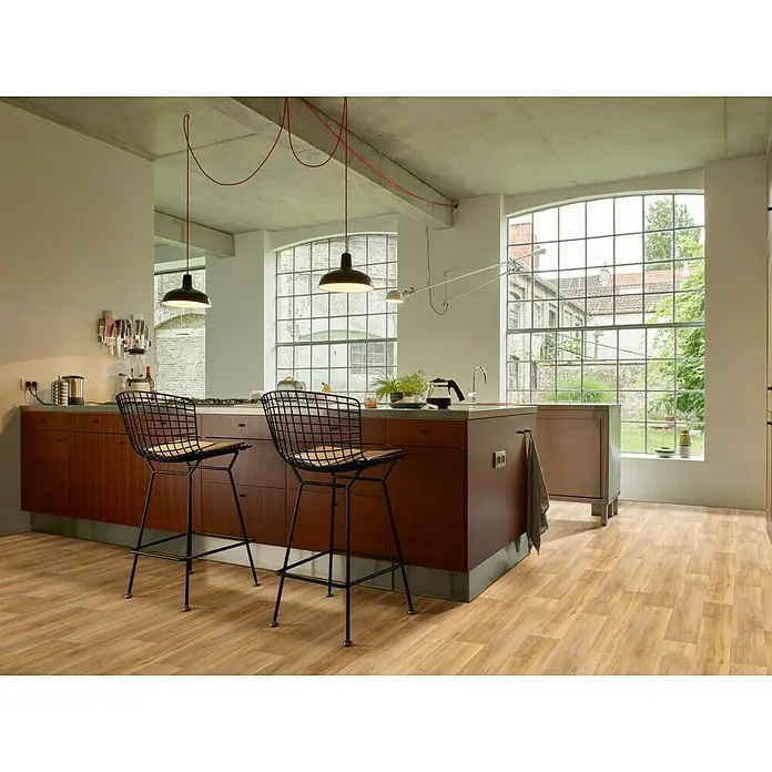 Beauflor PVC-Boden Meterware Novo - Holzoptik, Breite: 300 cm, Braun - Eine moderne Küche mit einer Insel, zwei Barhockern und großen Fenstern. Die Pendelleuchten setzen stilvolle Akzente.