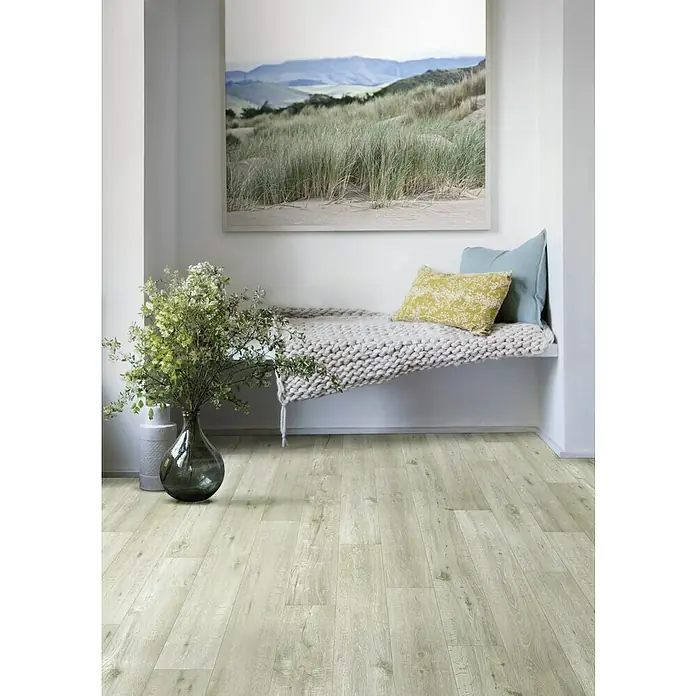 Beauflor PVC-Boden Meterware Cupid - Holzoptik, Breite: 400 cm, Hellgrau - Einladende Raumecke mit hellem Holzboden, gemütlicher Sitzbank, Kissen und einem Landschaftsbild an der Wand. Dekorative Blumen runden das Bild ab.