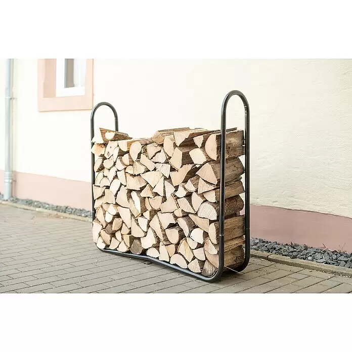 ShelterLogic Kaminholzregal - 121,9 x 25 x 104 cm, Stahl, Schwarz - Ein schwarzes Metall-Brennholzregal, gefüllt mit gestapelten Holzscheiten, im Freien auf einem gepflasterten Bereich.