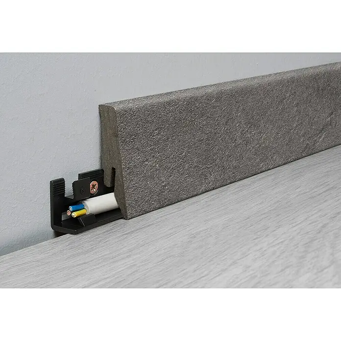 LOGOCLIC Aquaprotect Sockelleiste K58 Pure - 260 cm x 18 mm x 58 mm, MDF/HDF - Nahaufnahme einer Sockelleiste aus grauem Steinmaterial mit Kabelkanal zur Kabelverlegung.