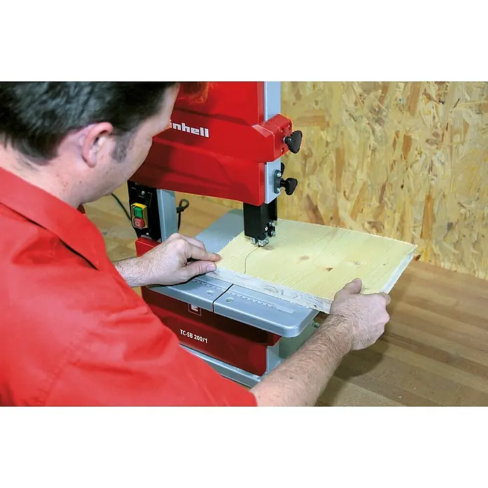 Einhell Hoja de sierra de cinta - L x An x Al: 1.400 x 8 x 0,65 mm - Un hombre opera una sierra de cinta Einhell TC-SB 200/1 para cortar una pieza de madera, centrándose en la máquina y la pieza.