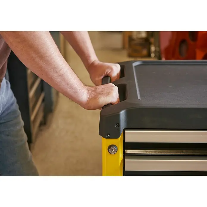 Stanley Carro portaherramientas STST74305-1 - L x An x Al: 67,6 x 42,6 x 85,9 cm, Número de cajones: 5 ud., Capacidad de carga: 300 kg - Primer plano de un hombre empujando un carro de herramientas amarillo con cajones, ofreciendo un almacenamiento duradero.