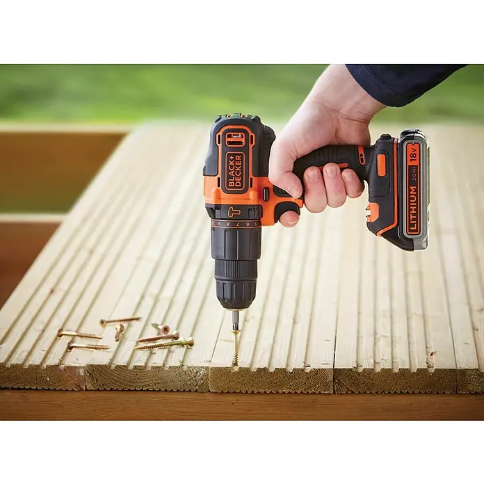 Black+Decker Taladro atornillador percutor de batería BDCHD18KB2 - 18 V, 2 baterías, 2 Ah, 40 Nm - Primer plano de un taladro inalámbrico Black+Decker atornillando un tornillo en una tabla de madera.