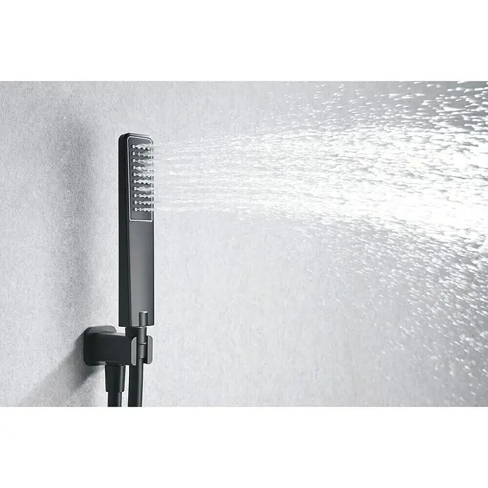 Imex Sistema de ducha empotrado Madeira - Negro - Cabezal de ducha negro con cabezal rectangular rociando agua. El cabezal de ducha está montado en un soporte de pared.