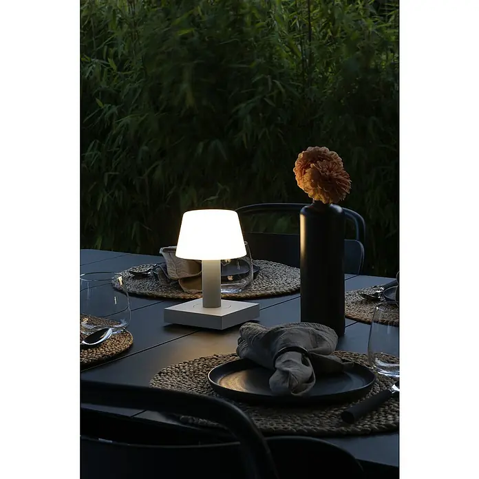 Konstsmide Akku-Tischleuchte Monaco - 2,5 W, L x B x H: 12,5 x 12,5 x 19 cm, Weiß, Warmweiß - Elegante Tischlampe, die ein warmes Licht auf einer stilvoll gedeckten Tafel spendet. Die Lampe erhellt die Szene mit sanftem Schein.