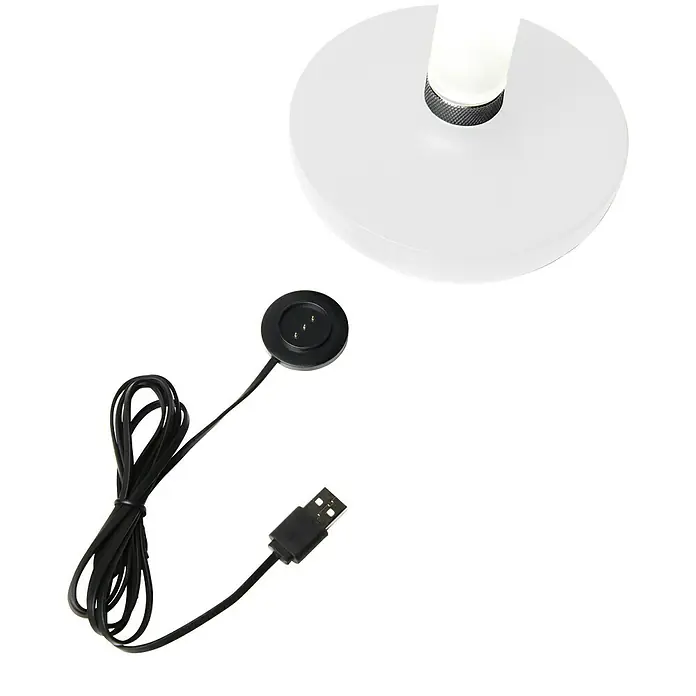 Konstsmide Akku-Tischleuchte Biarritz - 2,5 W, L x B x H: 13,5 x 13,5 x 20,5 cm, Weiß, Warmweiß - Nahaufnahme einer weißen Lampe mit Ladekabel. Das Kabel ist schwarz und hat einen USB-Anschluss.