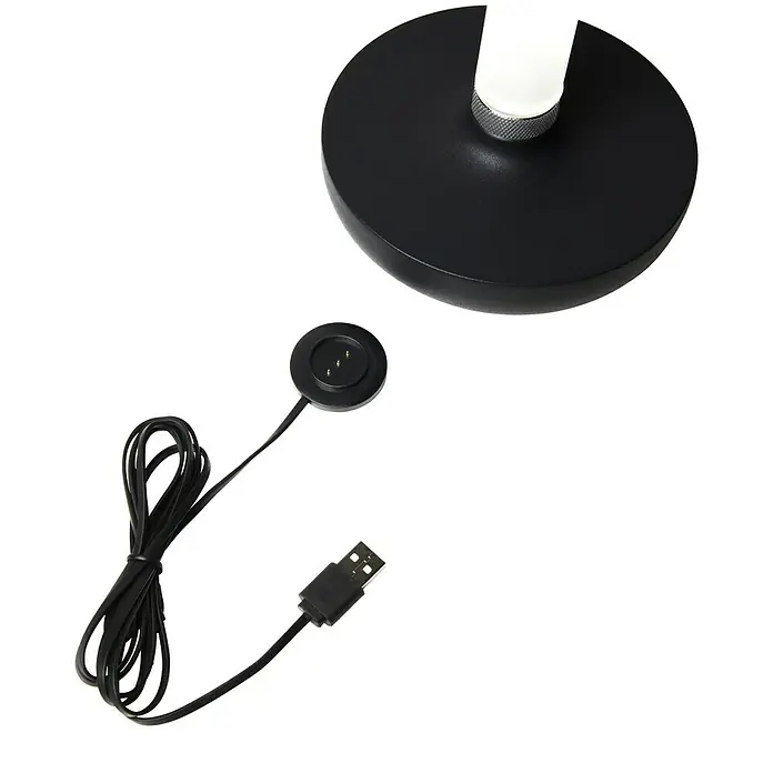 Konstsmide Akku-Tischleuchte Biarritz - 2,5 W, L x B x H: 13,5 x 13,5 x 20,5 cm, Schwarz, Warmweiß - Nahaufnahme eines Lampenfußes und eines USB-Ladekabels. Das Kabel ist schwarz und liegt neben dem Lampenfuß, der ebenfalls schwarz ist.
