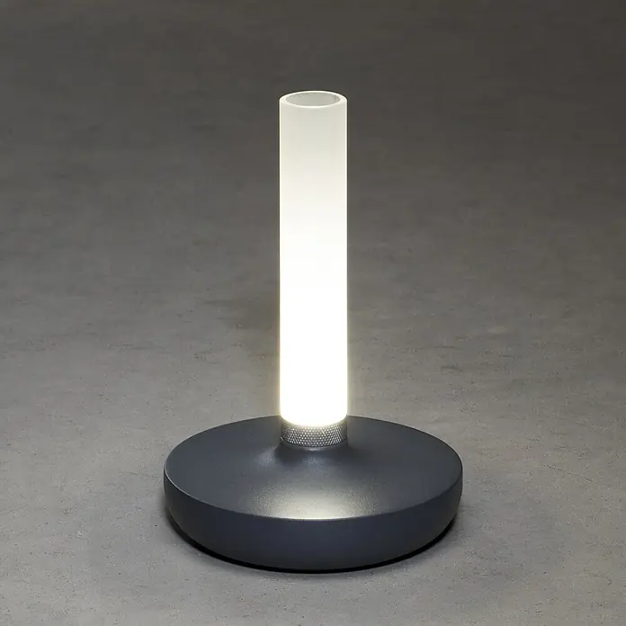 Konstsmide Akku-Tischleuchte Biarritz - 2,5 W, L x B x H: 13,5 x 13,5 x 20,5 cm, Grau, Warmweiß - Elegante Tischleuchte mit zylindrischem Lampenschirm und grauem Sockel, die ein warmes, sanftes Licht ausstrahlt. Perfekt für modernes Ambiente.