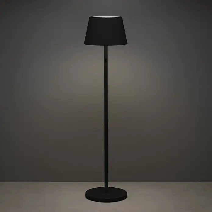 Konstsmide Außenleuchte Pomezia - Akkubetrieben, 10 W, RGBW, 35 x 35 x 150 cm, Mit Leuchtmittel, Schwarz - Eine schwarze Stehlampe mit einem dunklen Lampenschirm, die ein sanftes Licht ausstrahlt und eine gemütliche Atmosphäre schafft.