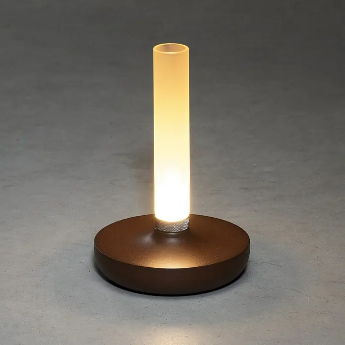 Konstsmide Akku-Tischleuchte Biarritz - 2,5 W, L x B x H: 13,5 x 13,5 x 20,5 cm, Rost, Warmweiß - Nahaufnahme einer modernen Tischleuchte mit einem braunen Sockel und einem zylindrischen, mattierten Lampenschirm.
