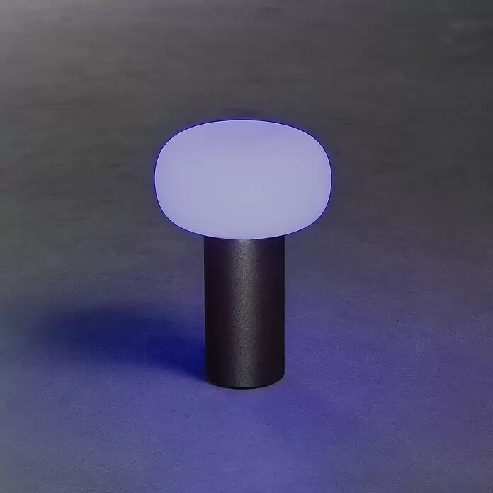 Konstsmide Akku-Tischleuchte Antibes - 2,5 W, L x B x H: 13 x 13 x 19 cm, Schwarz, Mehrfarbig - Moderne Lampe mit dunklem zylindrischem Fuß und leuchtendem purpurweißem Kugelkopf, die blaues Licht auf die Oberfläche wirft.