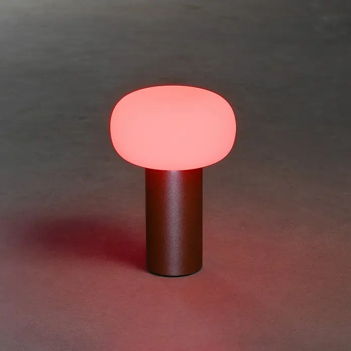 Konstsmide Akku-Tischleuchte Antibes - 2,5 W, L x B x H: 13 x 13 x 19 cm, Rost, Mehrfarbig - Rotes Tischleuchte mit einem zylindrischen Sockel und einer kugelförmigen Lampe, die ein warmes, rotes Licht ausstrahlt.