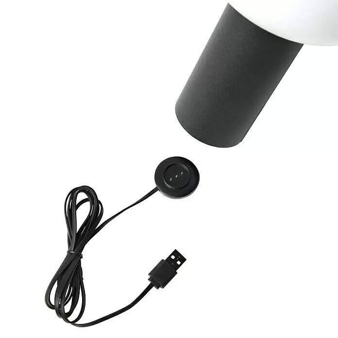 Konstsmide Akku-Tischleuchte Antibes - 2,5 W, L x B x H: 13 x 13 x 19 cm, Schwarz, Mehrfarbig - Schwarzes USB-Ladekabel mit magnetischem Rundstecker, teilweise das weiße und schwarze Gerät zeigend, das es lädt.