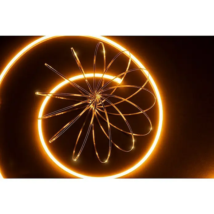 Alverlamp Tira LED a metros Neon - Largo: 100 m, Color de luz: Blanco neutro, 9 W, 1.308 lm - Primer plano de una lámpara dorada abstracta que forma un patrón espiral con círculos radiantes sobre un fondo oscuro.