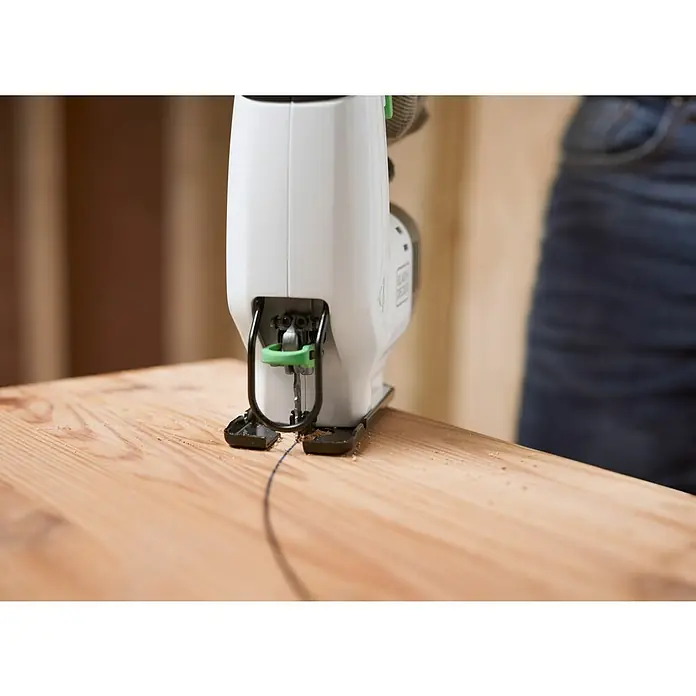 Black+Decker reviva Sierra de calar de batería - 12 V, 1 batería, 1,5 Ah - Una sierra de calar corta con precisión una tabla de madera, dejando una línea fina y curva. La herramienta es blanca con detalles verdes.