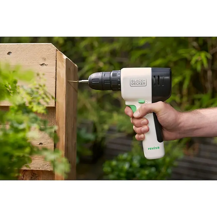 Black+Decker reviva Taladro atornillador de batería - 12 V, 1 batería, 1,5 Ah, 26 Nm - Un taladro Black+Decker Reviva se utiliza para atornillar un tornillo en un trozo de madera. La herramienta eléctrica está siendo sujetada por una mano.
